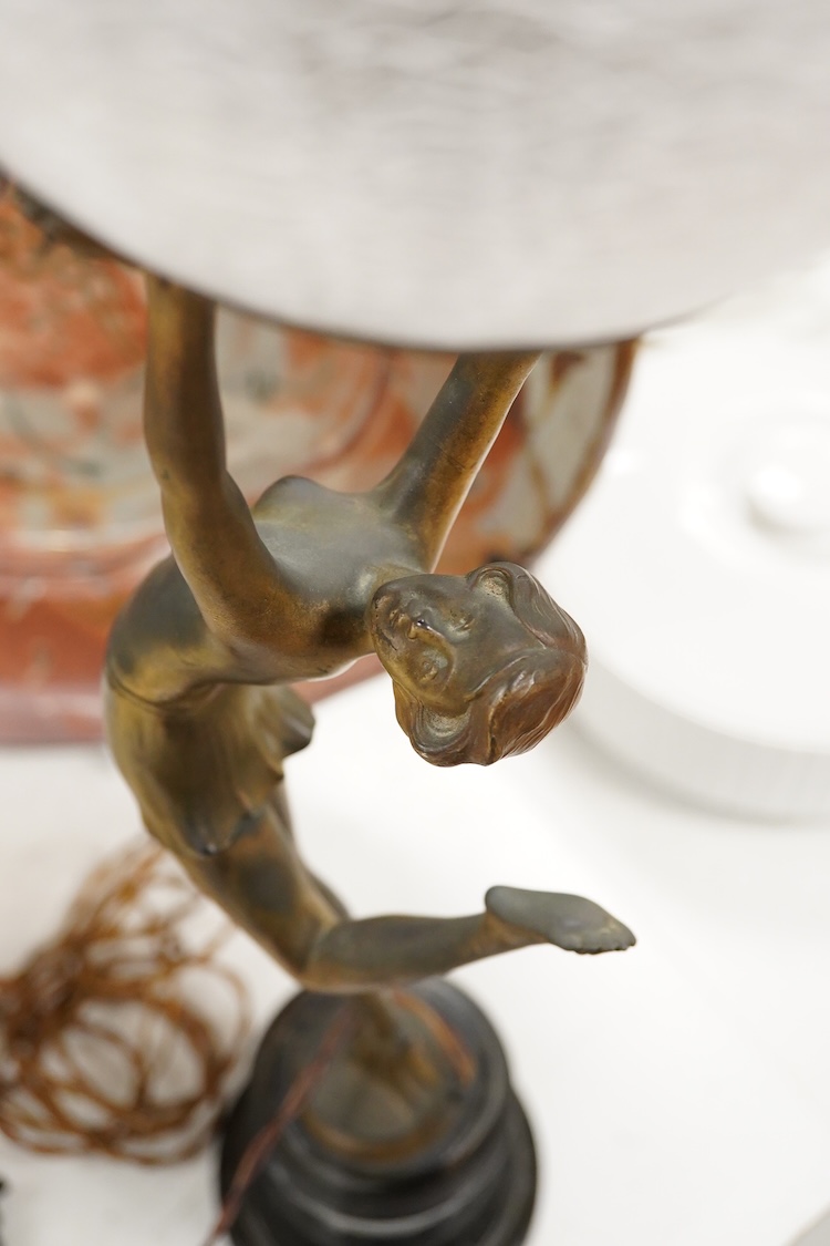 An Art Deco spelter ‘Dancing Girl’ table lamp with a frosted glass globe shade, 57cm high
